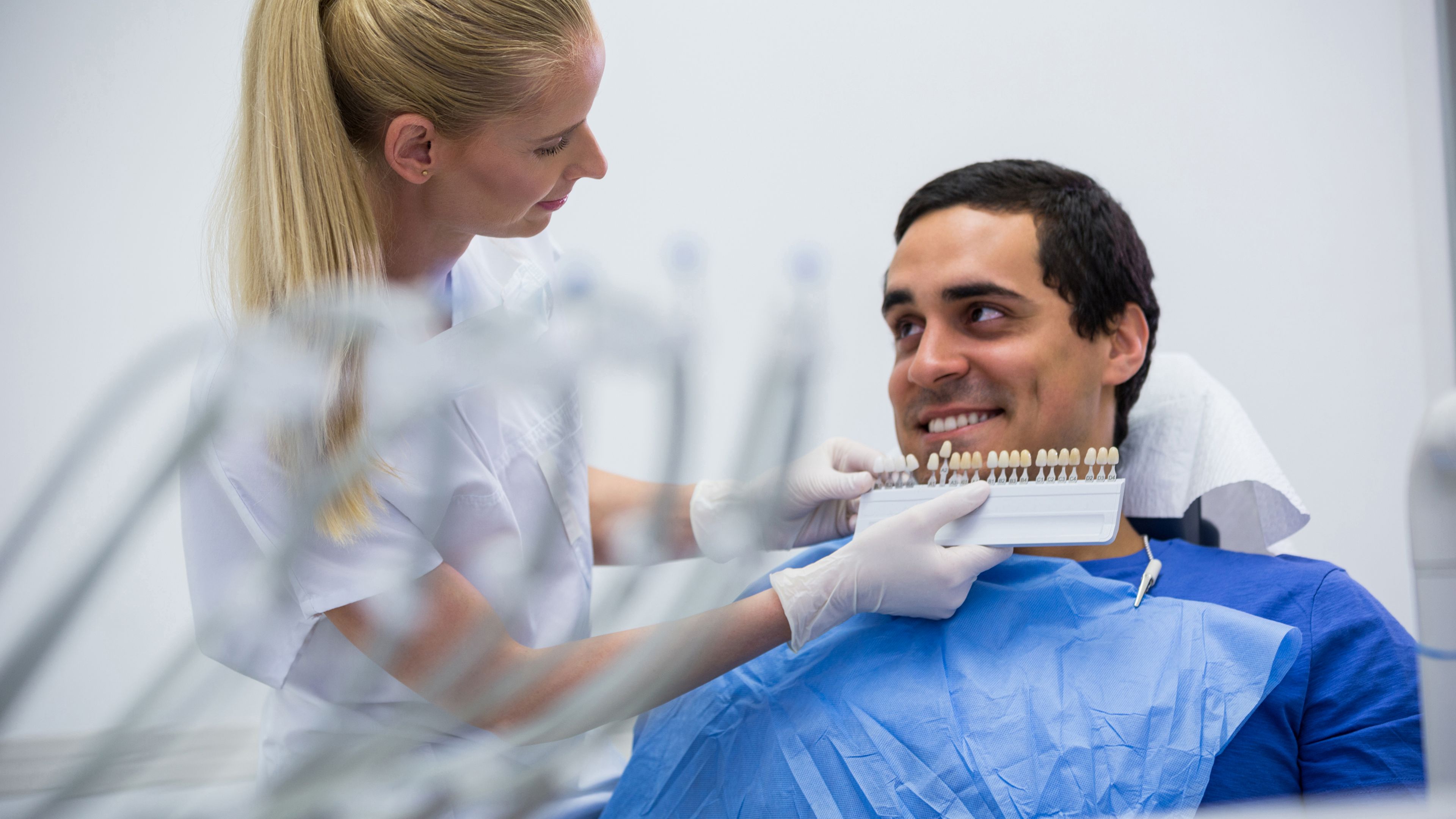 Scelta del colore del dente con scala cromatica durante una riabilitazione implanto-protesica a Mirano